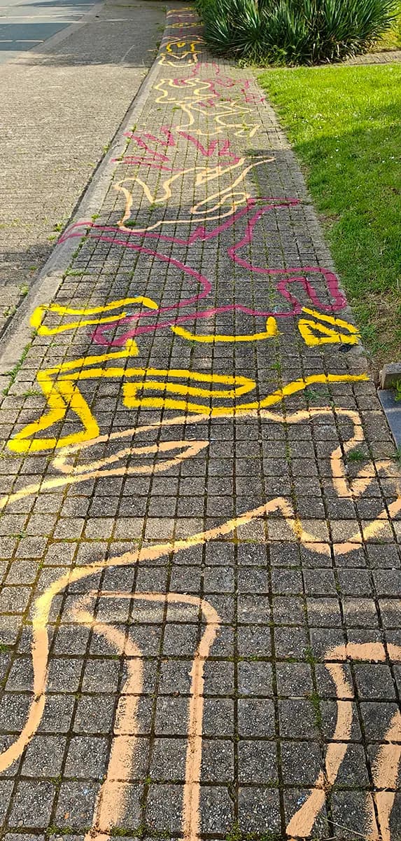 De helpers van de jeugdbeweging tekenden elkaars omtrek in geel, roze en zalmkleur. Wie kan hun houding nadoen?